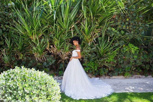 Novia con vestido largo en un jardín tropical