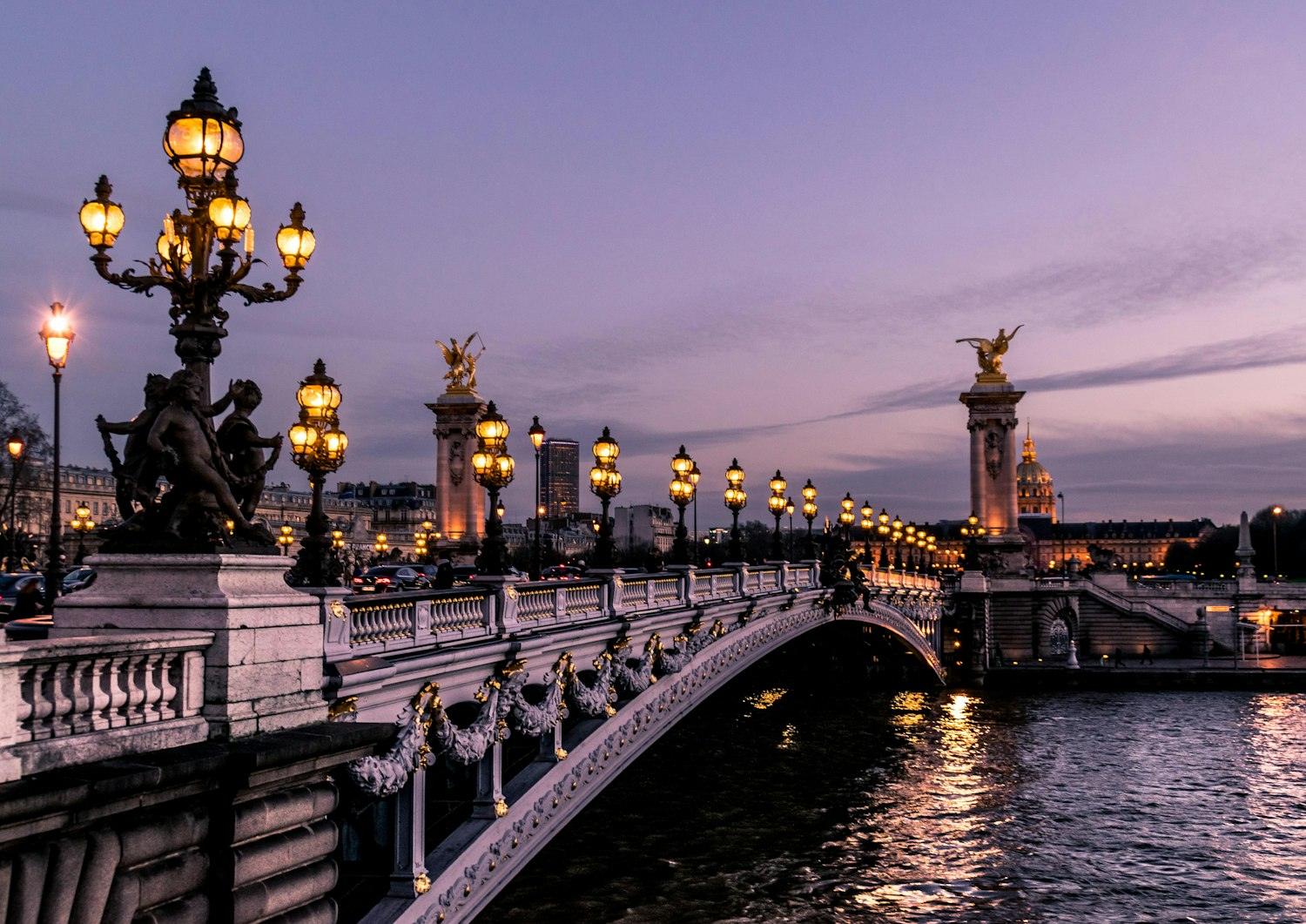 Puente Alejandro III y farolas al atardecer en París, Francia