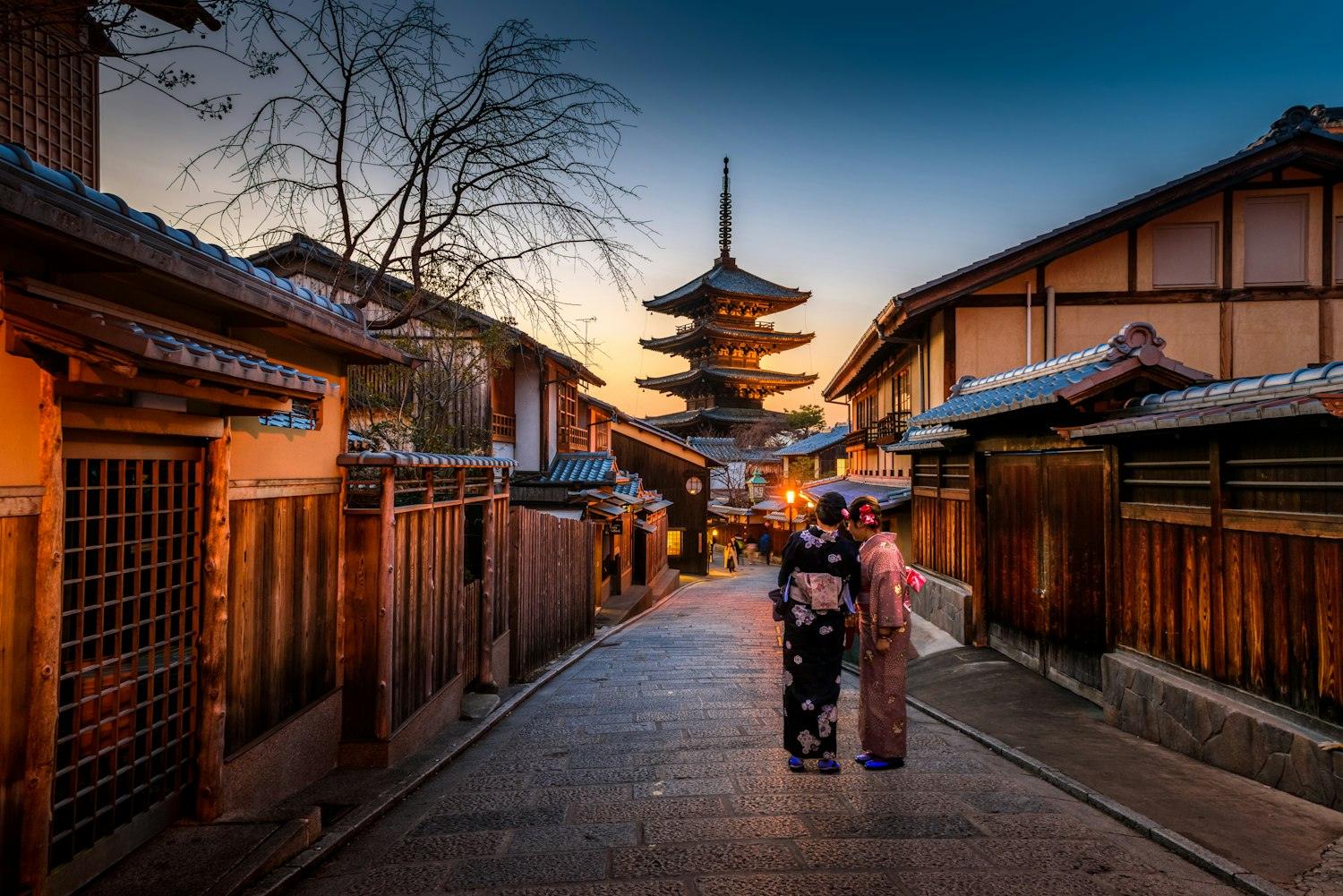 Calle tradicional de Kioto con una pagoda al fondo al atardecer, Japón